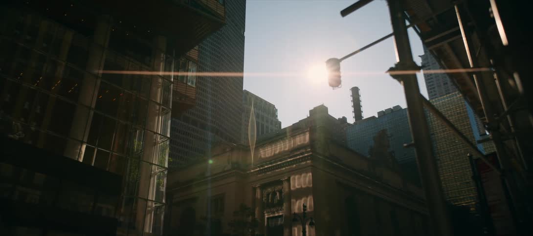Sun shines between tall buildings reflecting light on the city facades
