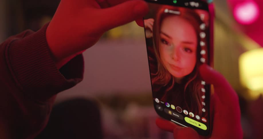 A woman is using a smartphone app to take a selfie