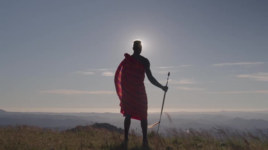 The man is standing on the windy mountain top
