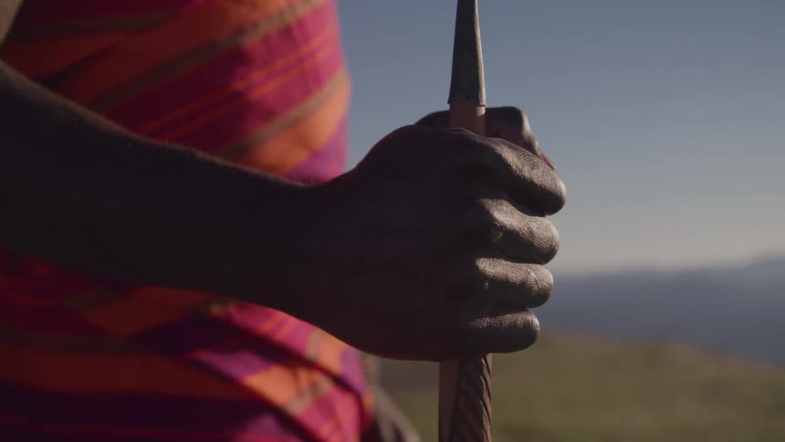 The man is holding a wooden spear