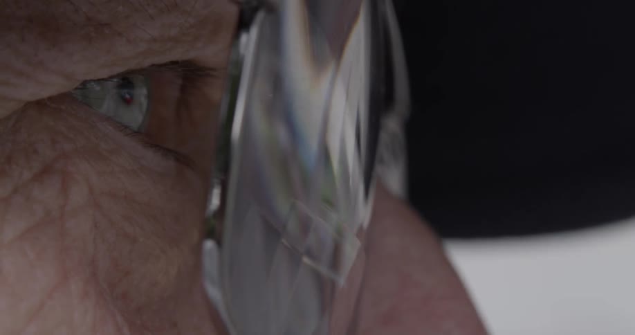 Moving vehicles reflect off of an elderly person's glasses