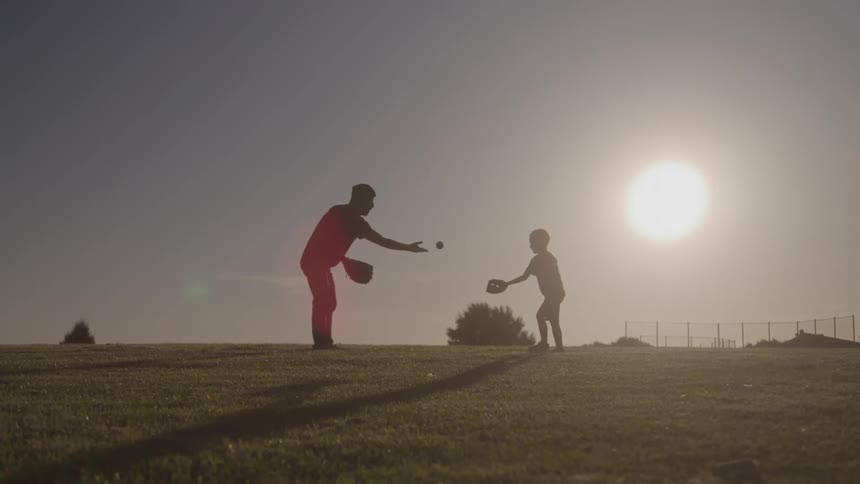 A father and son play catch together