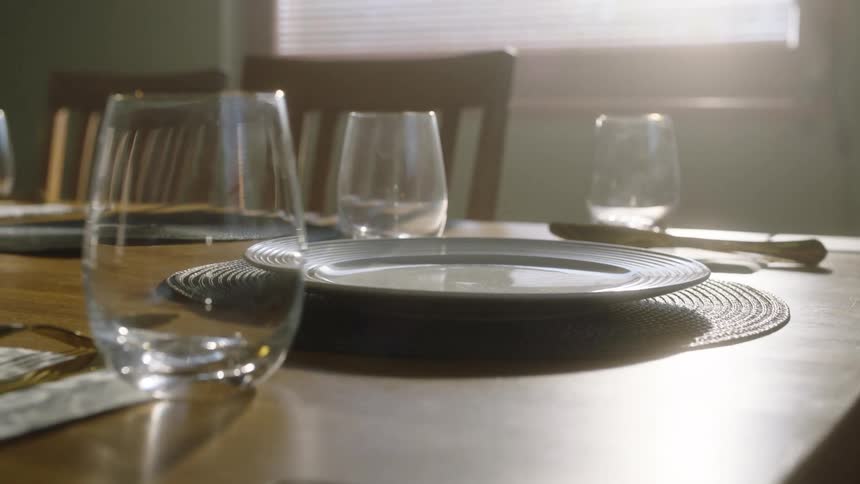 Woman sets the table in a dining room during the daytime