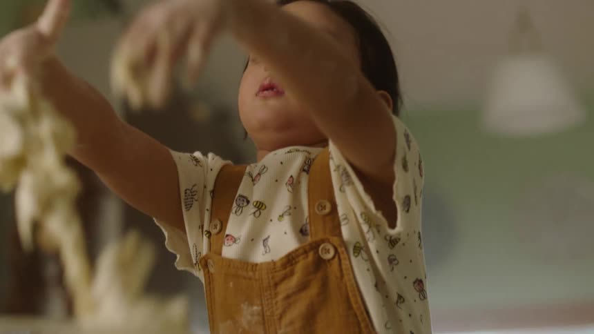The child is mixing the dough in the bowl