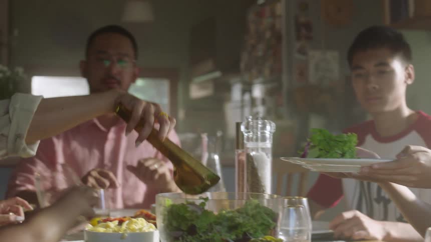 A family shares a meal as food is served at the table
