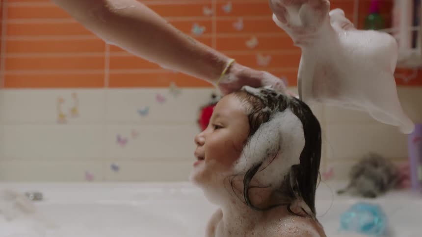 The child is taking a bath at home