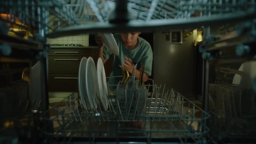 The child loads the dishwasher