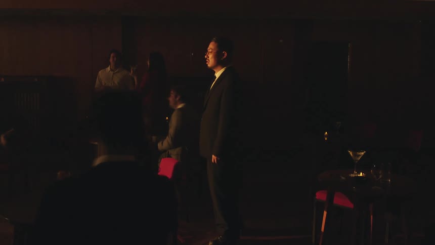 A person runs past in a dimly lit space with a large crowd the runner is captured in a blurred motion