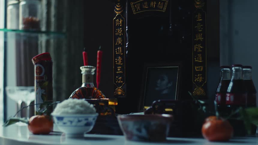 A table filled with chinese dishes and three bottles of coke with chinese inscriptions in the background