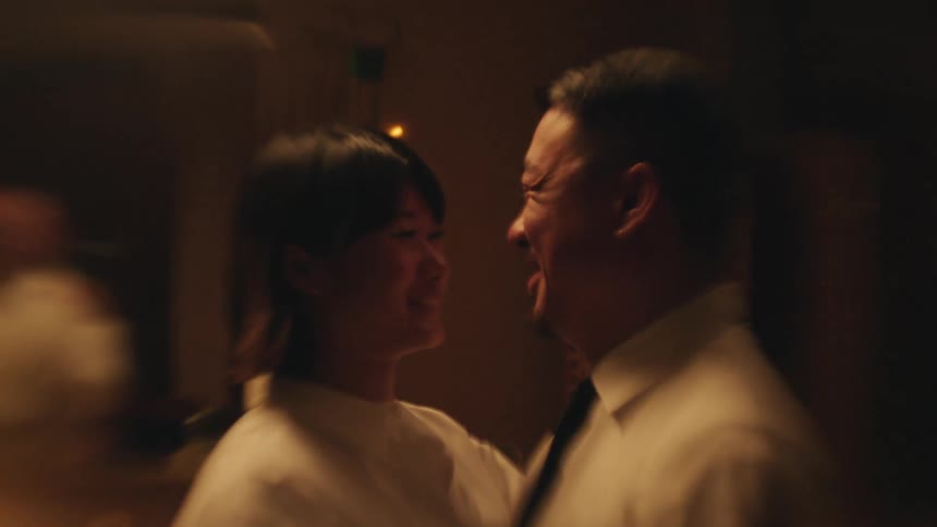 A couple romantically looks into each others eyes indoors
