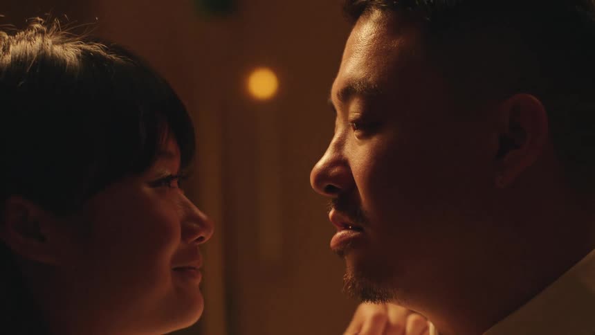Couple shares an intimate moment together in a dimly lit room
