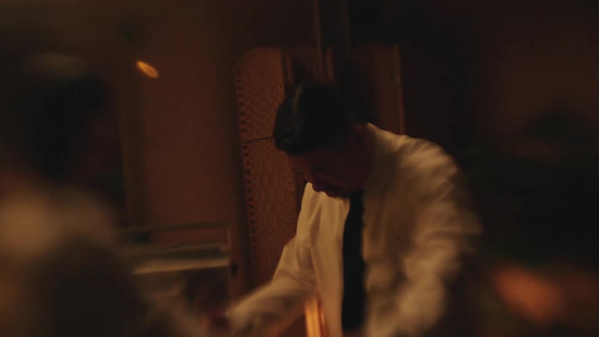 A couple dances together in a warmly lit room