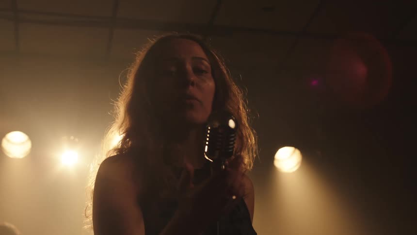 The woman is singing into the microphone
