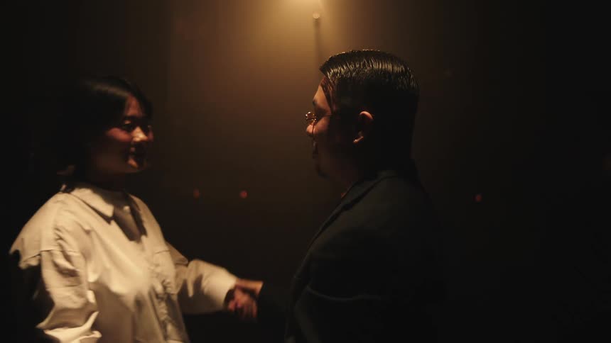 Man and woman dancing in a dark room with low lighting