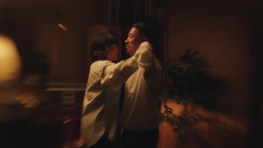 A couple having fun dancing together in their living room at night