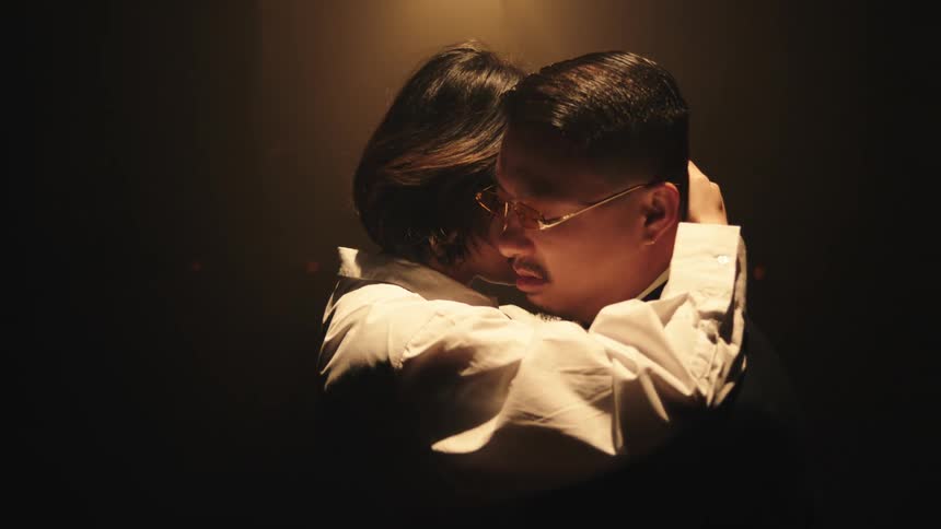 A couple dancing on a stage at night wearing traditional chinese attire
