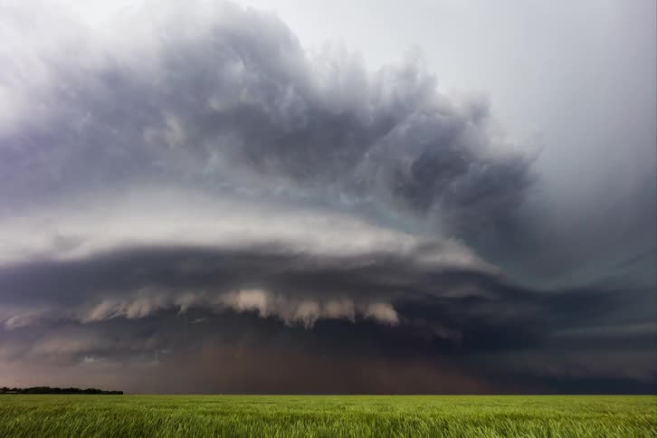 Storm clouds gathering over a field darkening the sky