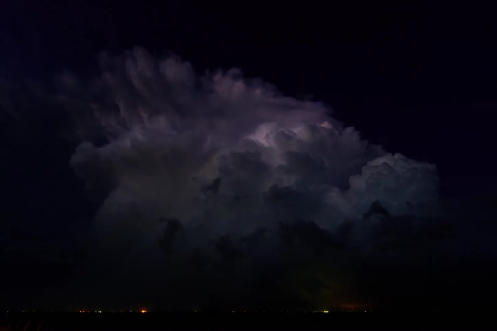 The large storm clouds spin at night and flash with lightning