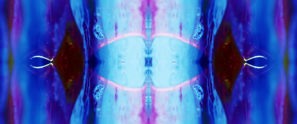 A vibrant abstract kaleidoscope of blues purples and oranges pulsates and shifts forming a mirrored pattern with liquid like textures and glowing outlines