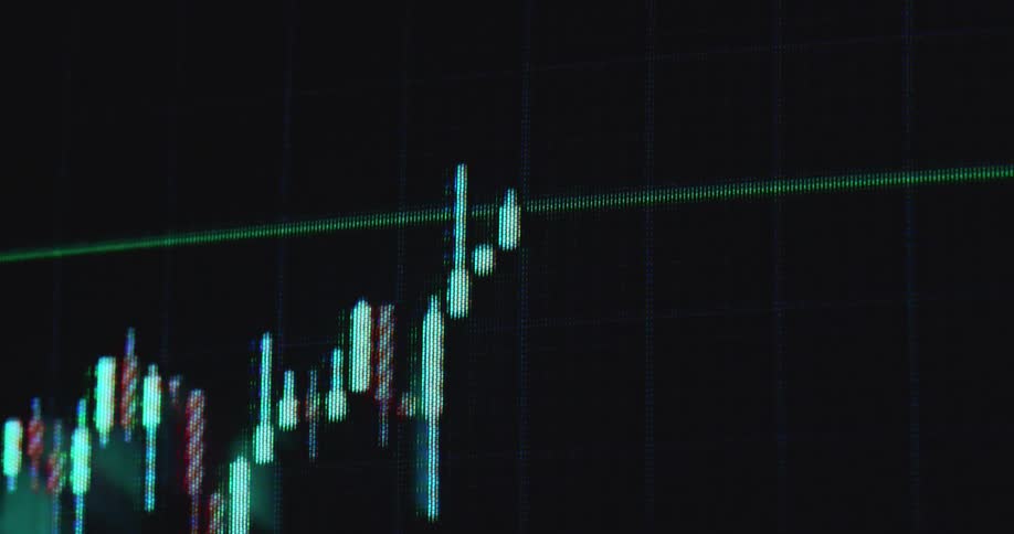 Handheld macro shot with dynamic camera movement of stock or crypto currency trading candlestick chart going up before crashing due to unexpected black swan event causing recession and economic depression on screen with grid and red candles
