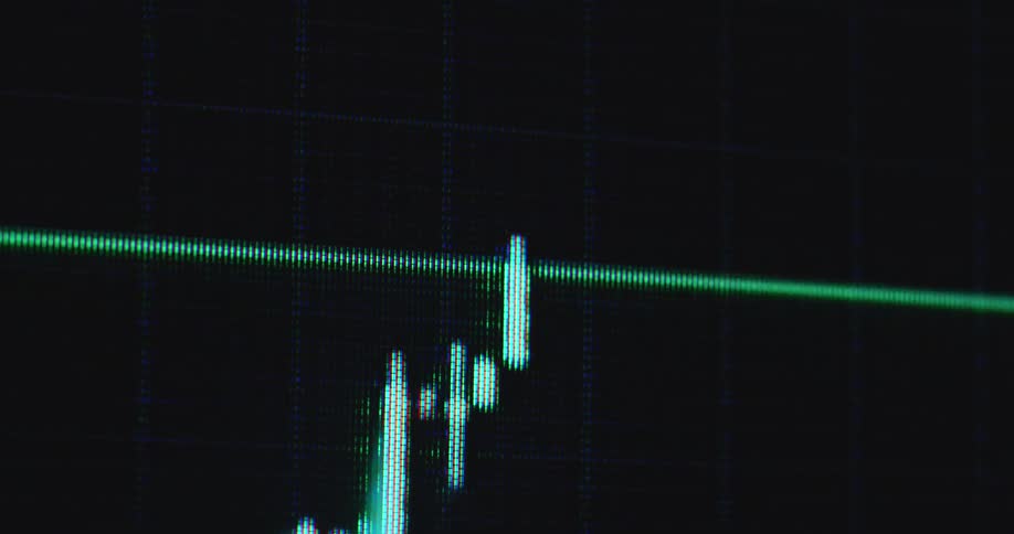 Trend line drawing red or green trading candles on monitor creating a candle stick chart pattern with upward tendency and great price development showing a successful trade with good performance and profit on black screen with grid