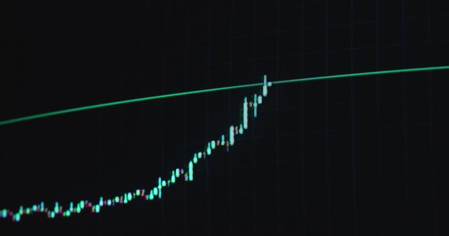 A candlestick chart or trading graph animation showing a stock price or crypto currency rising over time with exponential growth and a positive trend or development on a dark computer screen with RGB pixels as symbol for a growing shares or bond market