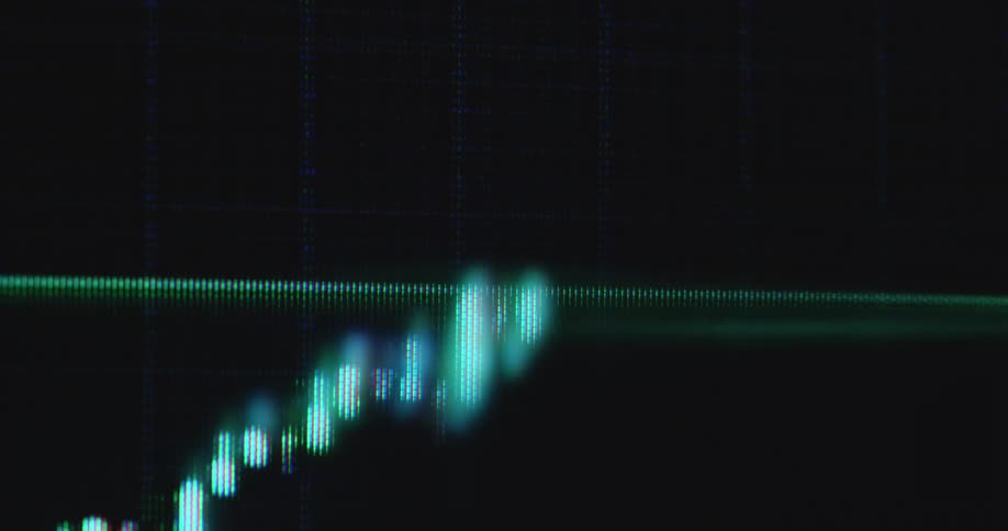 Handheld macro close-up of bullish financial market chart or candlestick trading graph on black screen displaying the UI of stock or crypto broker application or platform as the price surges and the value of the asset increases during investment bull run