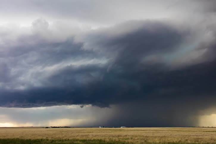 Storm clouds gathering over a field showing the first signs of a tornado