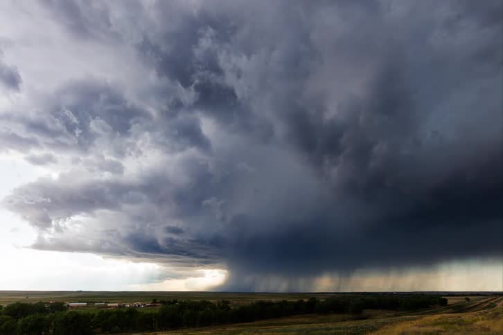 Dark storm clouds releasing heavy rain over the countryside