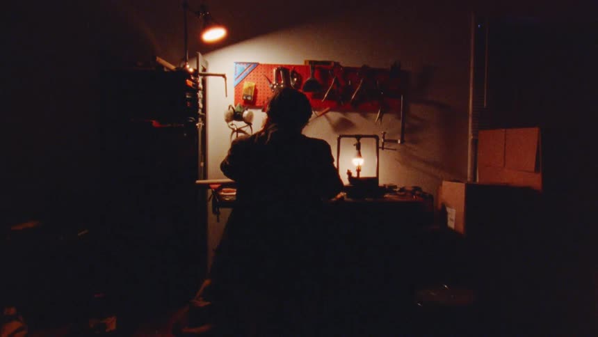 The man is working in his dark workshop