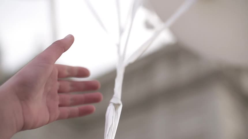 A hand reaches out to grab some strings