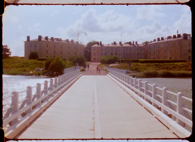 Small group of people walking around a bridge next to a building outdoors during day time