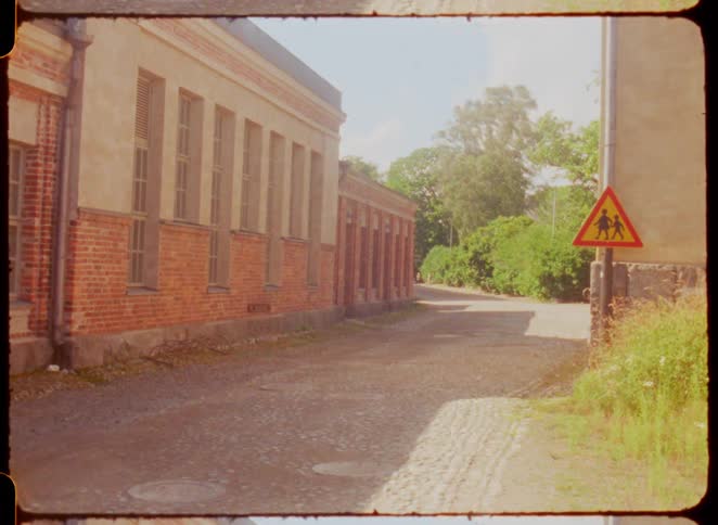 A quiet cobblestone street stretches beside old brick buildings