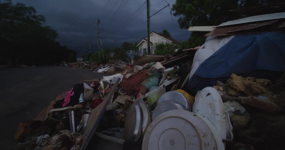 A huge pile of garbage is on the curb
