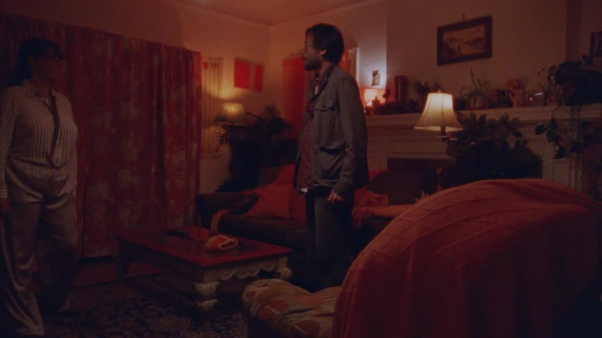 A man and a woman in a dimly lit living room