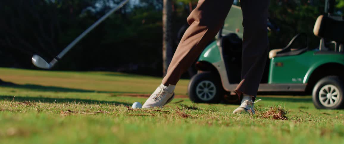 The man hits the ball while playing golf