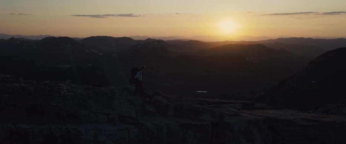 The person is hiking with a backpack on the mountain