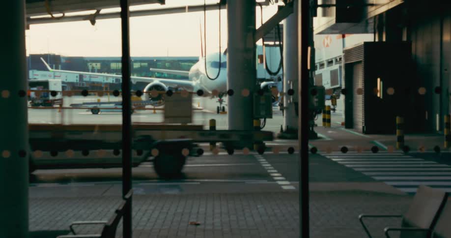 Work vehicles pass by airport buildings during the daytime