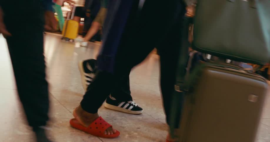 People walking around carrying lugagge on an airport