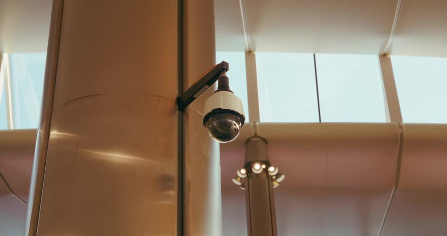 Security camera fixed on a pillar of a building indoors