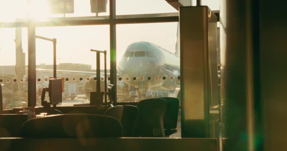 Airplane parked on the airport seen from the window on the airport lounge outdoors during day time