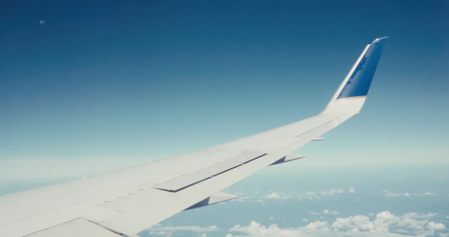 Wing of an airplane flying on the sky outdoors during day time