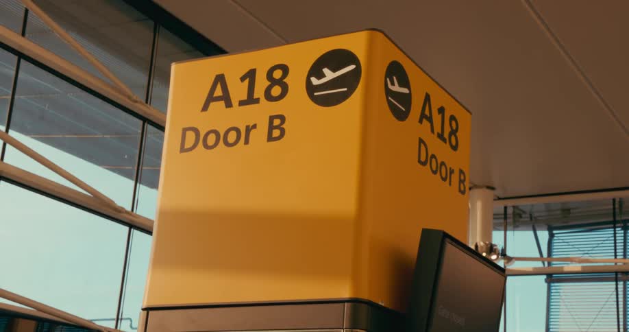 Yellow and black airport sign indoors during day time