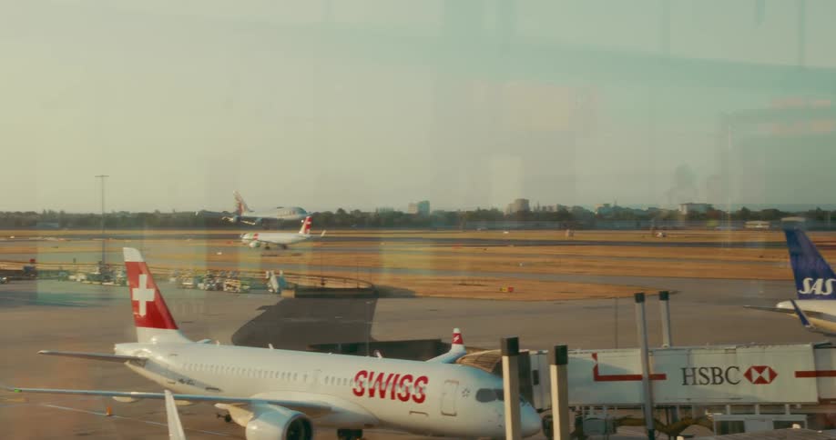 Airplane landing on the runway of an airport outdoors during day time seen through the airport window