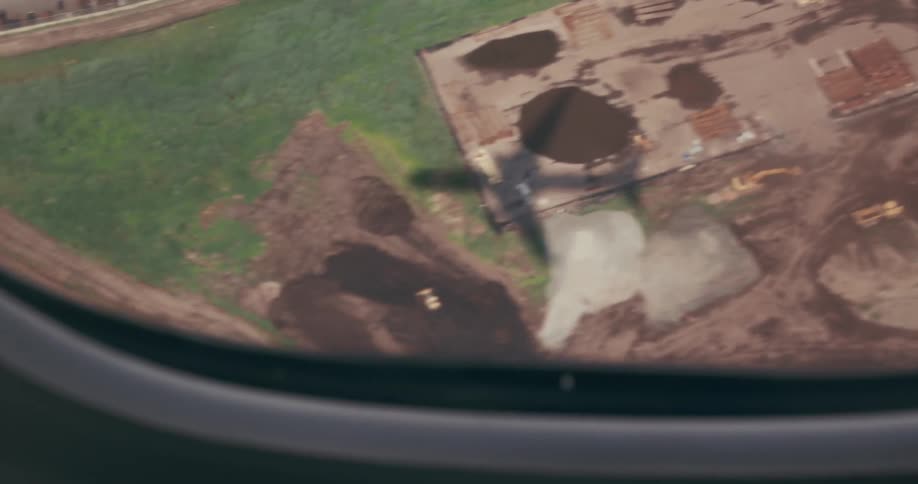View from the window of an airplane in midflight of the shadow reflecting on the city ground