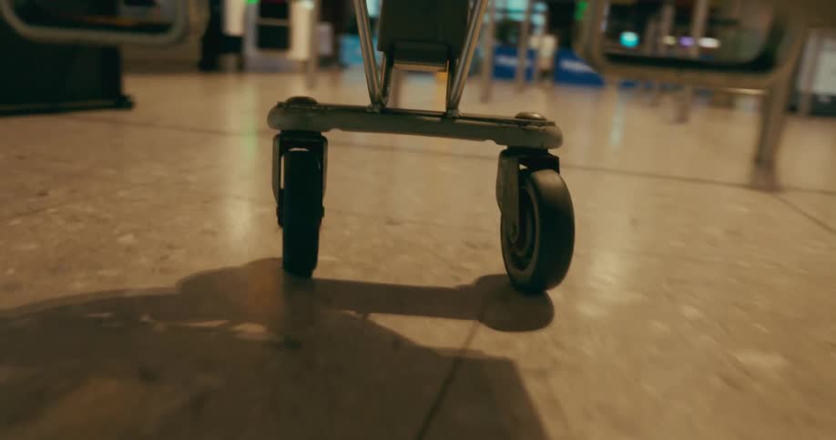 Point of view luggage cart wheels going through and airport terminal