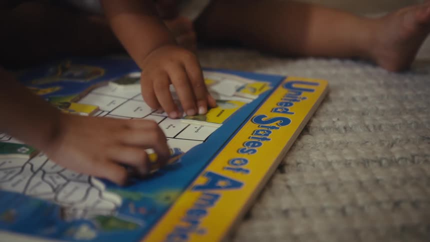 Hands of two children putting together a puzzle