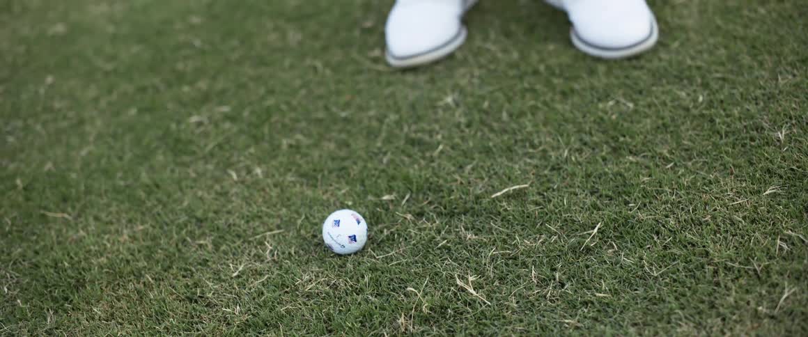 The girl hits the golf ball on the course