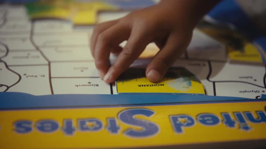Hands of toddlers playing with a puzzle indoors