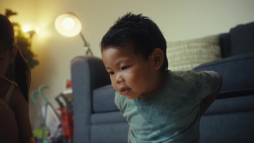 Two small children sitting on the living room rug playing